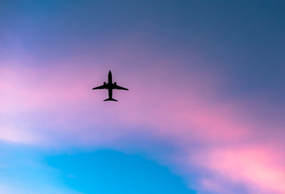 Directly below shot of airplane against sky during sunset