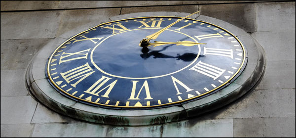 Low angle view of clock on wall