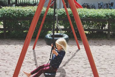 Children playing on swing in playground