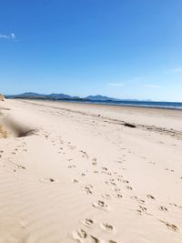 Scenic view of beach against clear blue sky