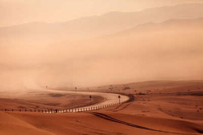 Winding empty road in the desert in fog