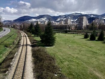 View of railroad tracks by buildings against sky