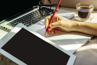 Midsection of woman using laptop on table