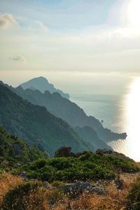 Scenic view of sea and mountains against sky