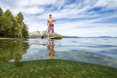 Man surfing in sea against sky