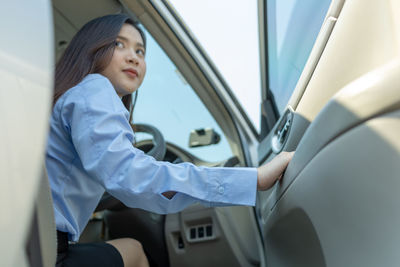 Young woman sitting in car