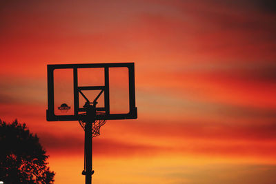 Low angle view of basketball hoop against sky during sunset