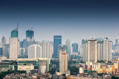 Modern buildings in city against clear sky