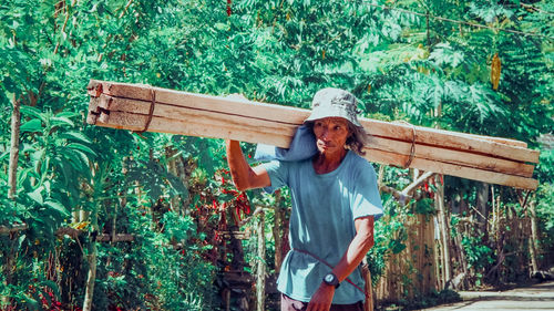 Old man father carrying log for his house