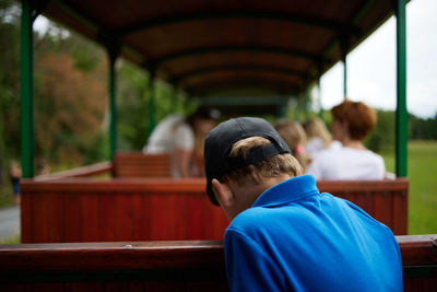 Rear view portrait of boy sitting in corridor