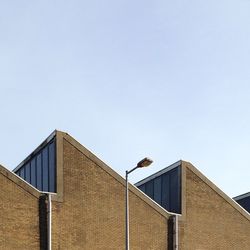 Low angle view of bird perching on roof