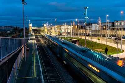 Train on railroad tracks in city against sky