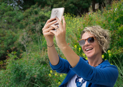 Portrait of smiling young woman using mobile phone