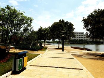 Footpath by swimming pool against sky