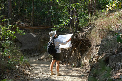 Rear view of woman walking in forest