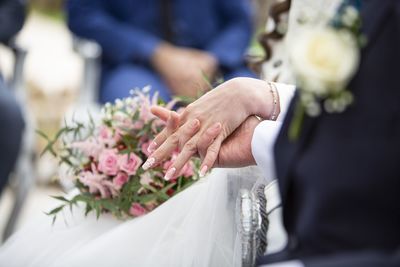 Midsection of bride holding bouquet