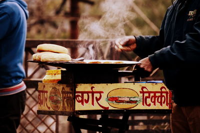 Midsection of man preparing food at street