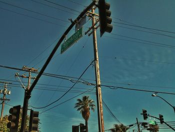 Low angle view of electricity pylon against blue sky