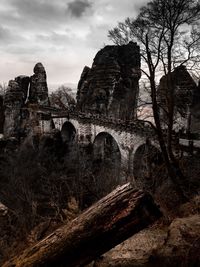Low angle view of old ruin building against cloudy sky