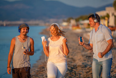 Rear view of friends standing on smart phone