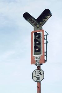 Low angle view of road signal against sky