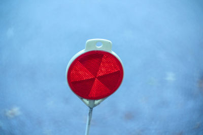 Close-up of red light against cloudy sky