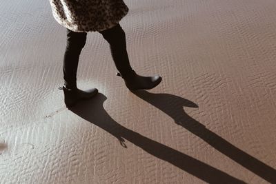 Low section of woman on shadow