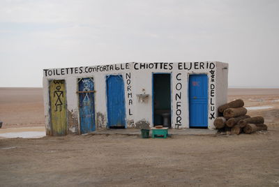 Information sign on beach against sky