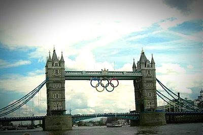 Bridge over river against cloudy sky