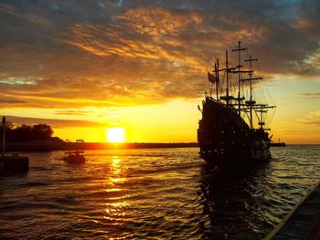 Silhouette sailboat on sea against sky during sunset