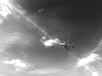 Low angle view of airplane flying against sky at night