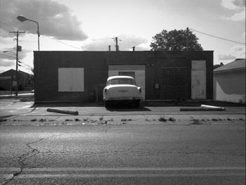 Cars on road against cloudy sky