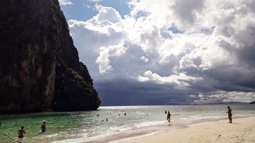 People on beach against sky