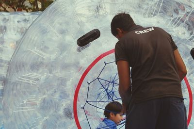 Rear view of boy standing in glass water