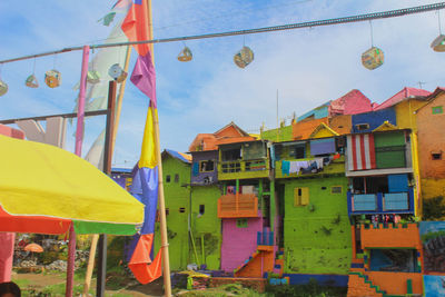 Multi colored flags hanging on building against sky