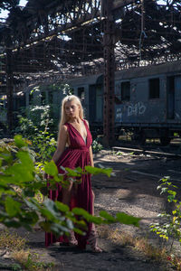 Portrait of woman standing by plants