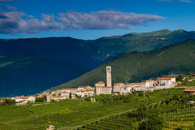 Scenic view of farm and houses against sky