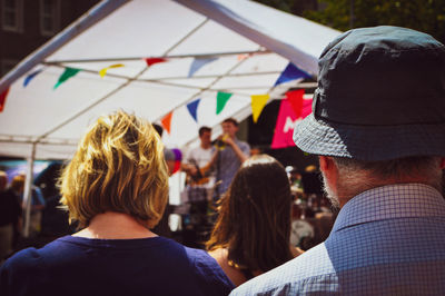 Rear view of people looking at camera