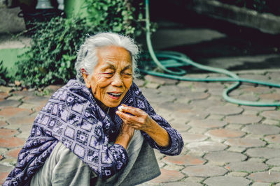 High angle view of woman crouching on floor outdoors