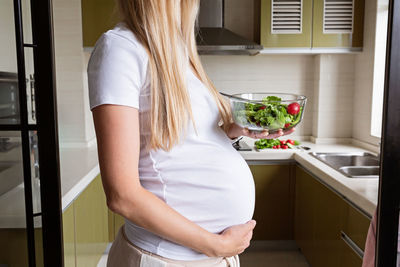 Midsection of woman standing at home