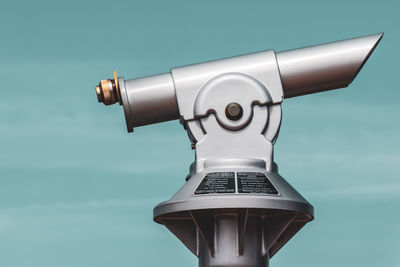 Close-up of coin-operated binoculars against sky