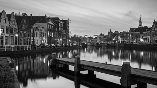 River by illuminated city against sky