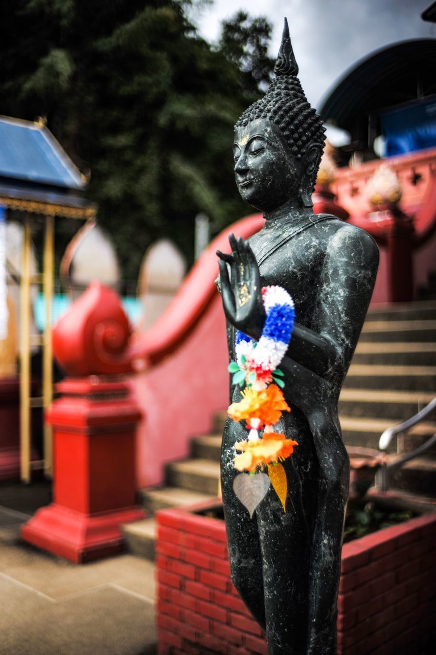 SCULPTURE OF BUDDHA STATUE AGAINST BUILDING