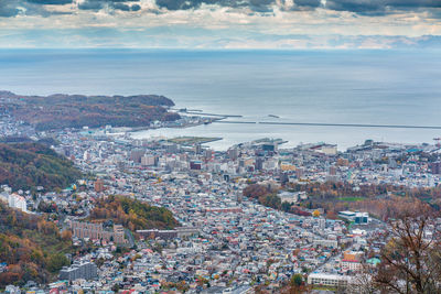 High angle view of townscape by sea against sky