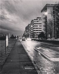 View of city street against cloudy sky