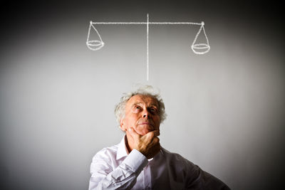 Portrait of man looking away against wall