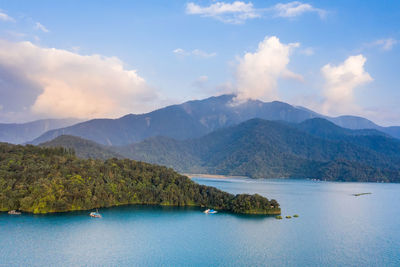 Scenic view of lake by mountains against sky