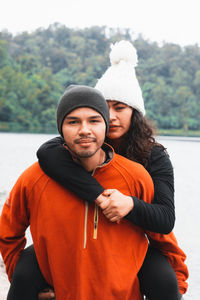 Portrait of young couple standing in park during winter