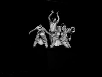 People dancing against black background