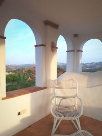 Chairs against sky seen through window